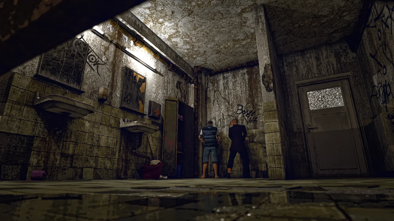 Two men stand in a worn public bathroom with cracked tiles, graffiti and exposed plumbing.