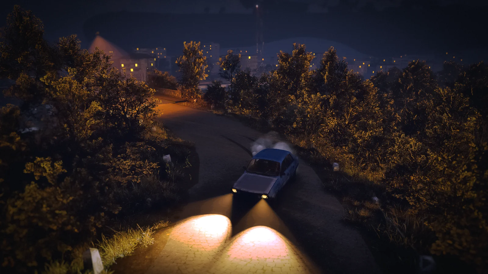 A car drifts around an autumn road at night, headlights cutting the dark.